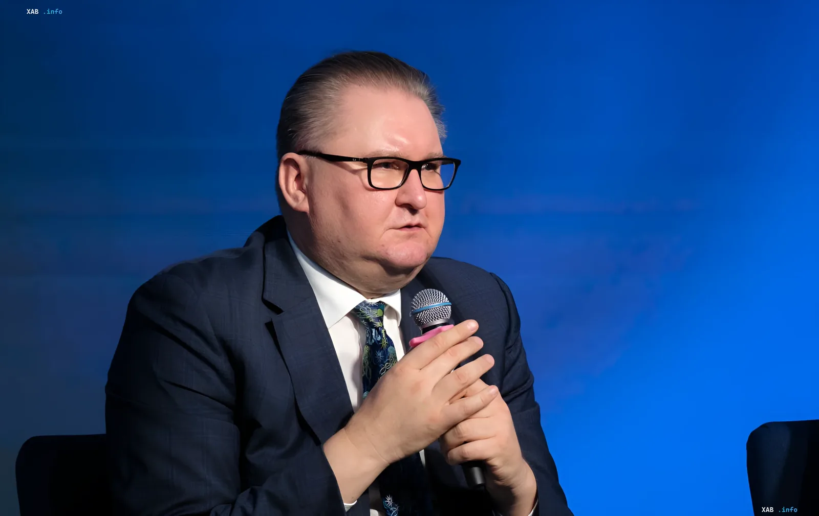 Венгерский политик на пресс-конференции с микрофоном на фоне синего экрана — обсуждение дорожной карты по национальным меньшинствам между Киевом и Будапештом