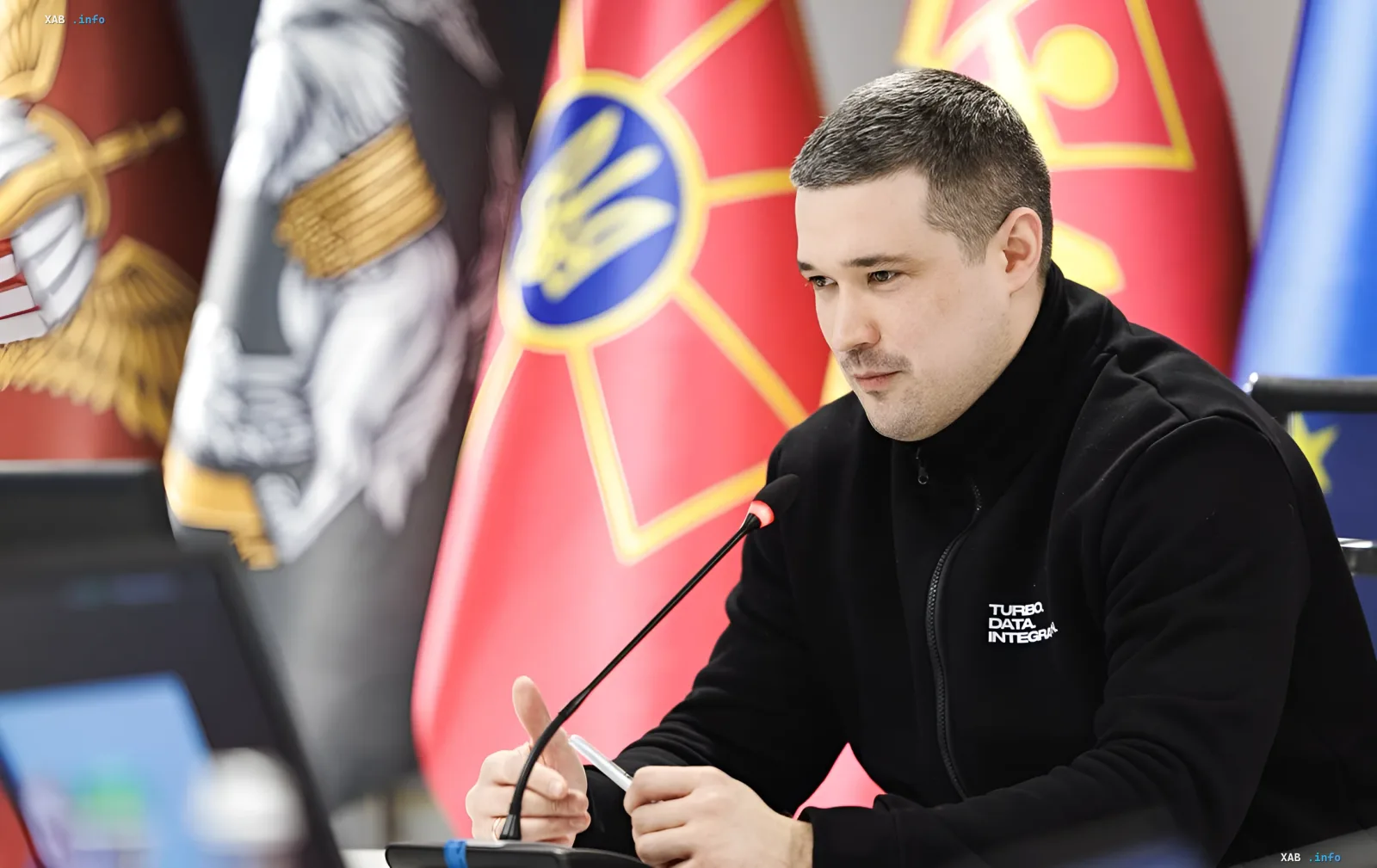 Украинский чиновник на совещании по безопасности логистики с флагами Украины и ЕС на фоне