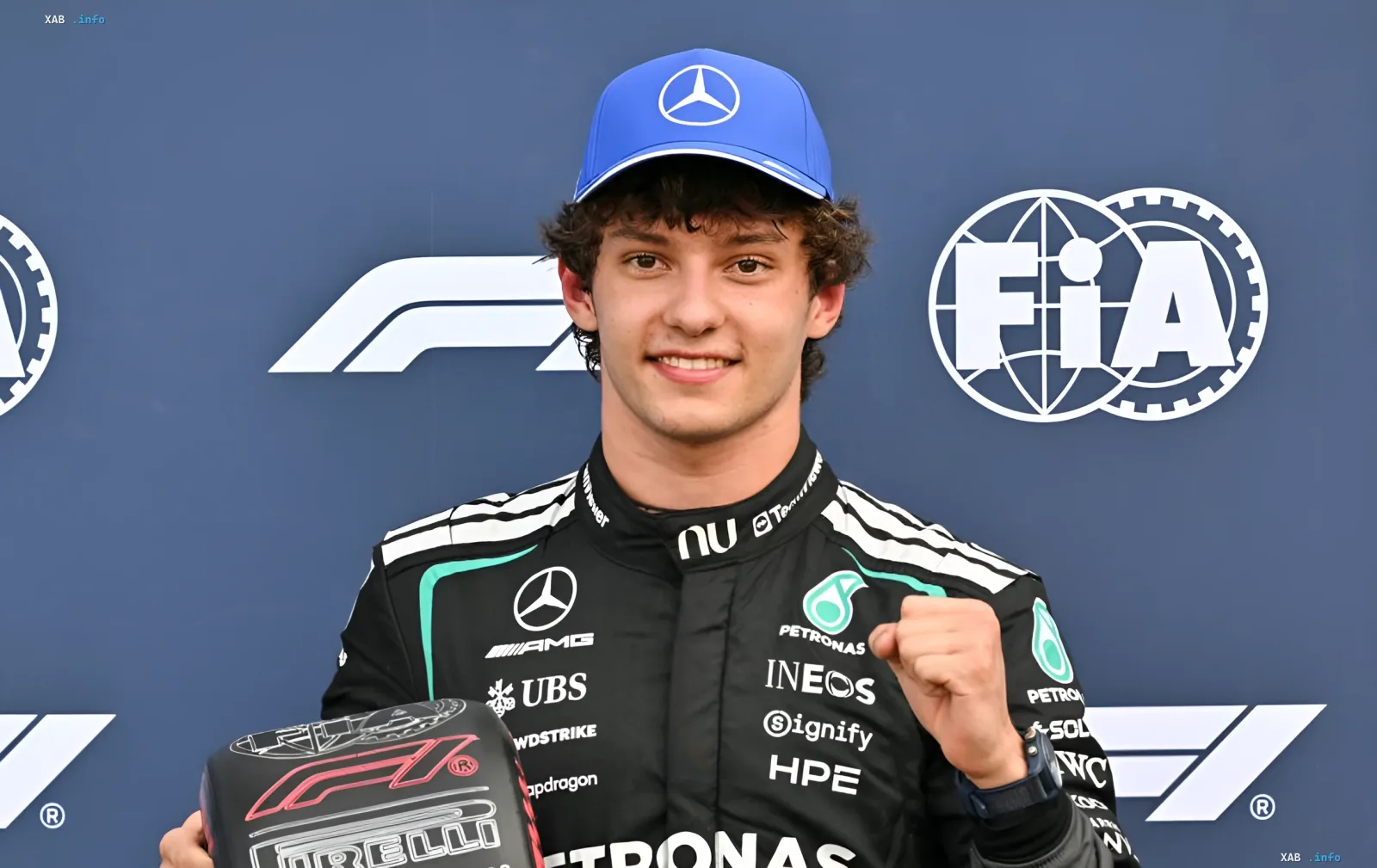 Джованни Антонелли в гончичном костюме Mercedes AMG Petronas с кубком Pirelli на фоне логотипов F1 и FIA, празднует победу в Гран-при Монако