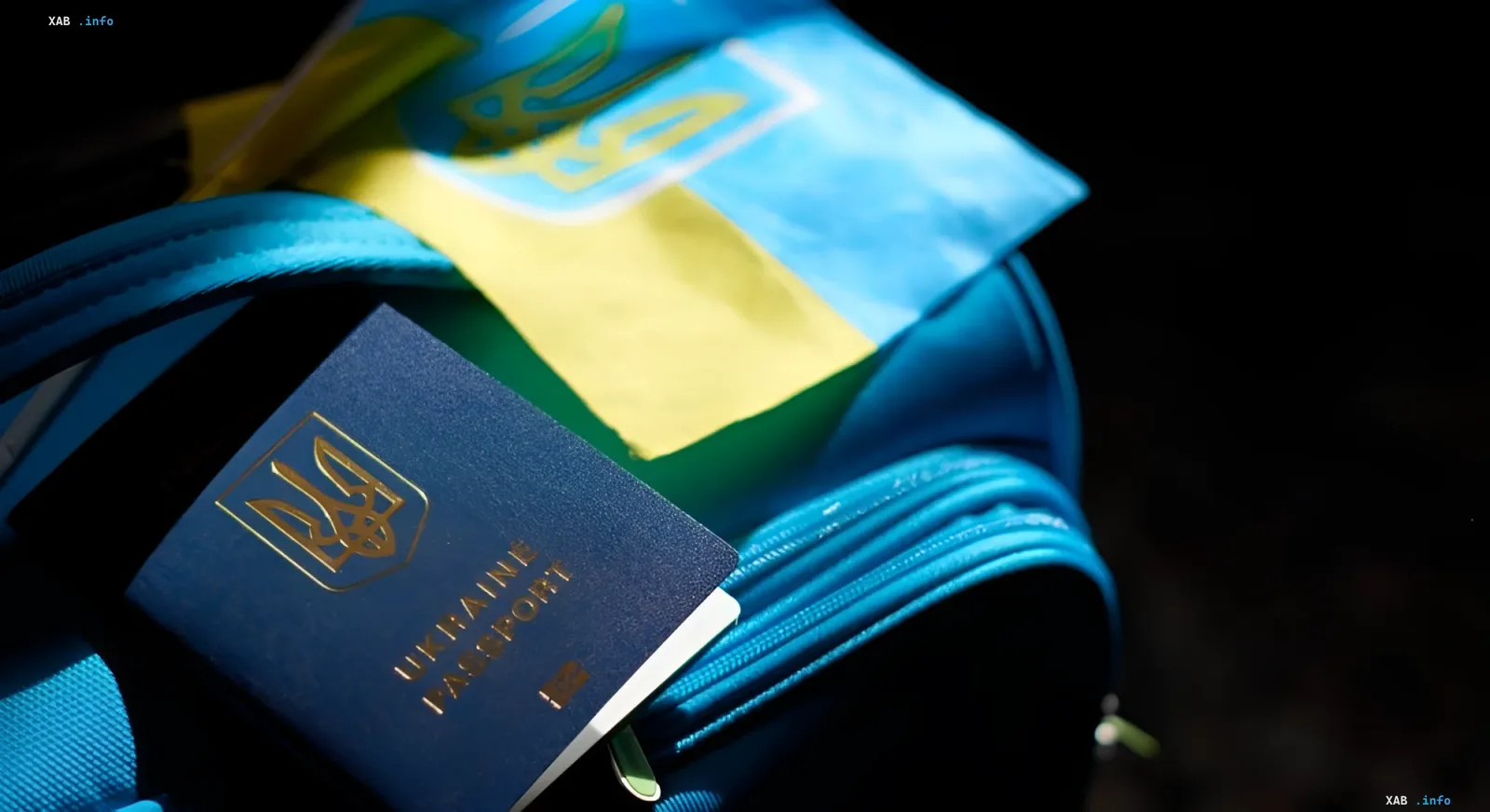 Ukrainian passport and flag on a blue backpack — symbol of migration and Poland’s search for new labor sources