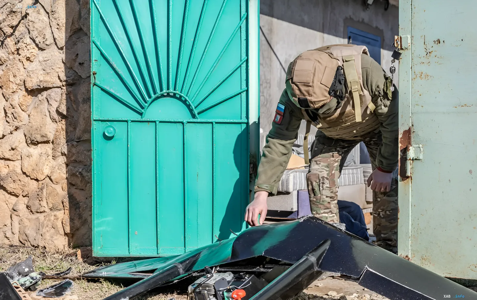 Солдат осматривает обломки дрона у ворот склада в Крыму после ночных ударов по логистическим объектам