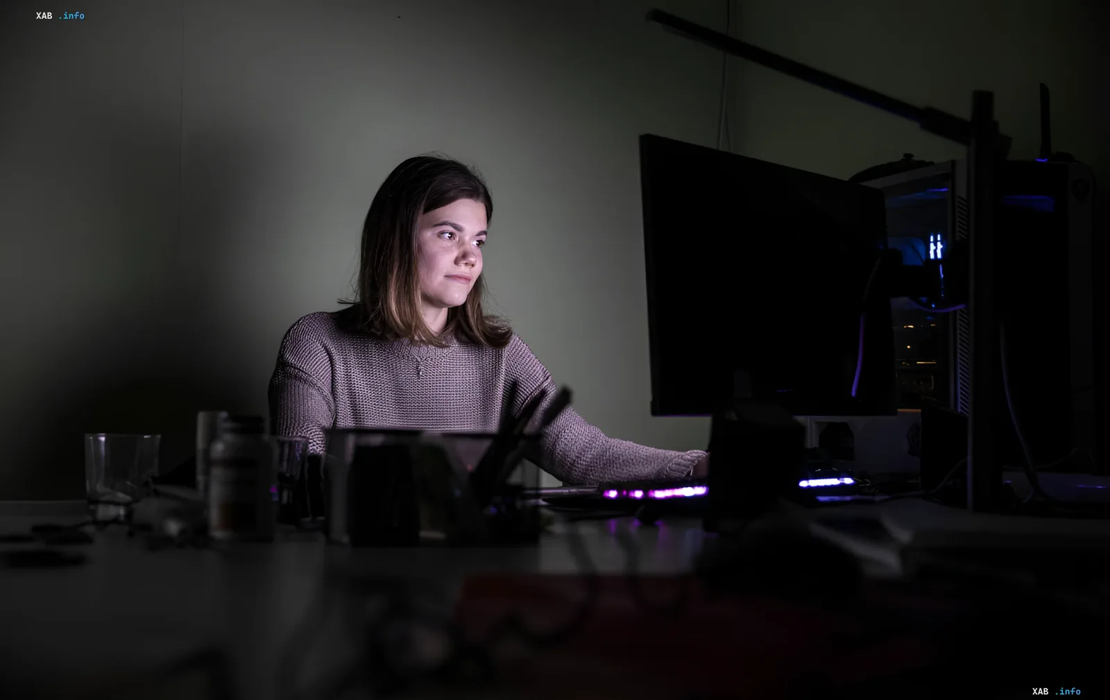 Frau arbeitet im Dunkeln an einem Computer während eines Stromausfalls in Saporischschja nach russischen Angriffen