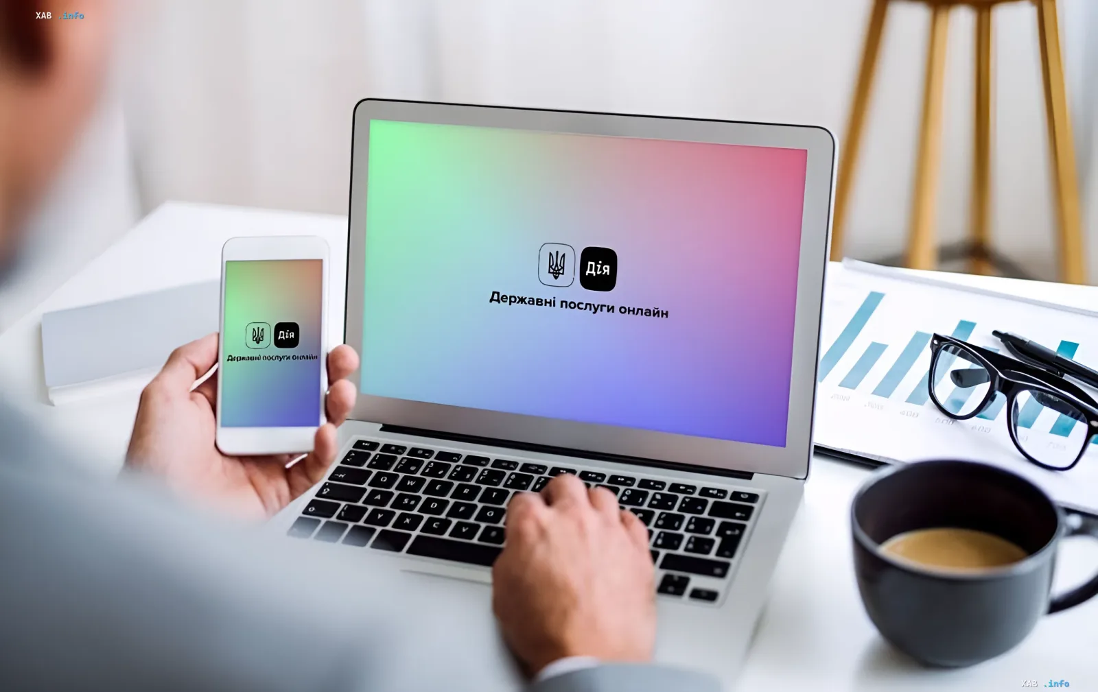 Person using the Diia app on smartphone and laptop, illustrating vulnerability to phishing attacks disguised as official government services