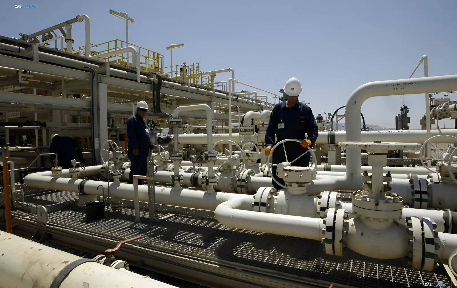 Workers on an oil platform adjusting pipe valves, symbolizing the impact of geopolitical conflicts on global oil prices.