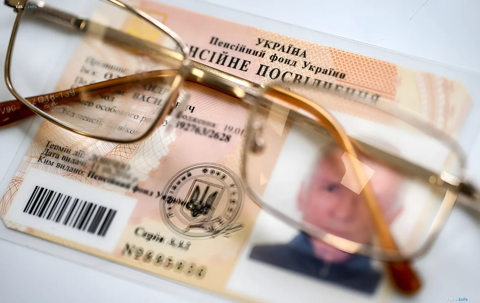 Ukrainian pension certificate under glasses, symbolizing pension reform and fight against pension devaluation
