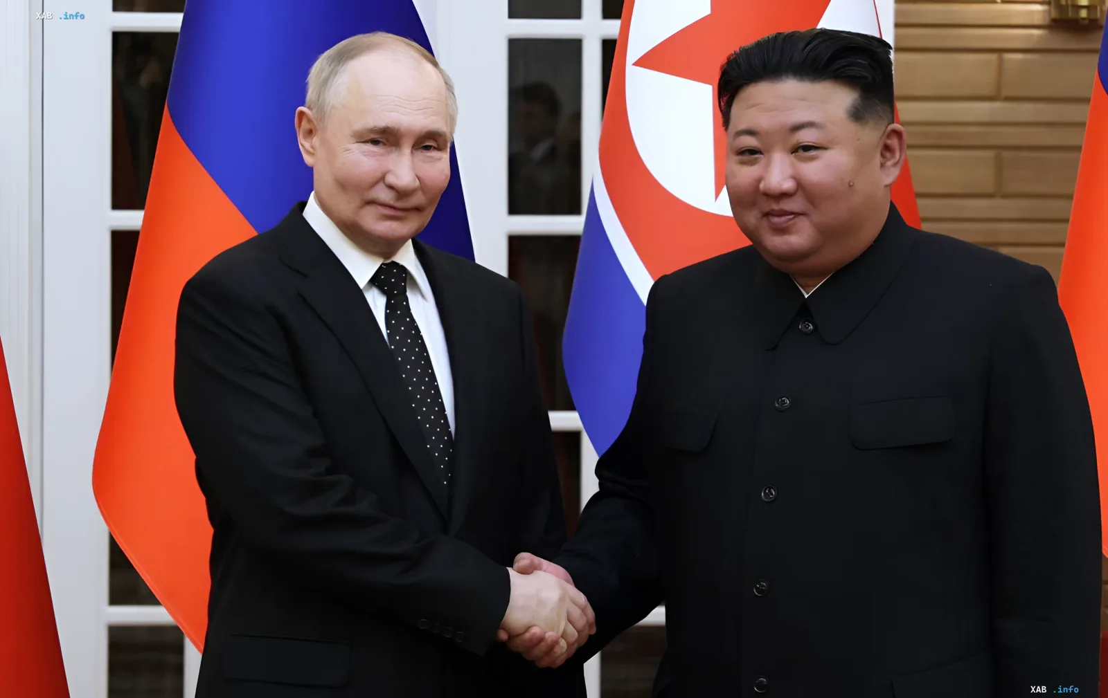 Владимир Путин и Ким Чен Ын пожимают руки на фоне флагов России и КНДР — символ растущего стратегического партнерства в обход санкций ООН