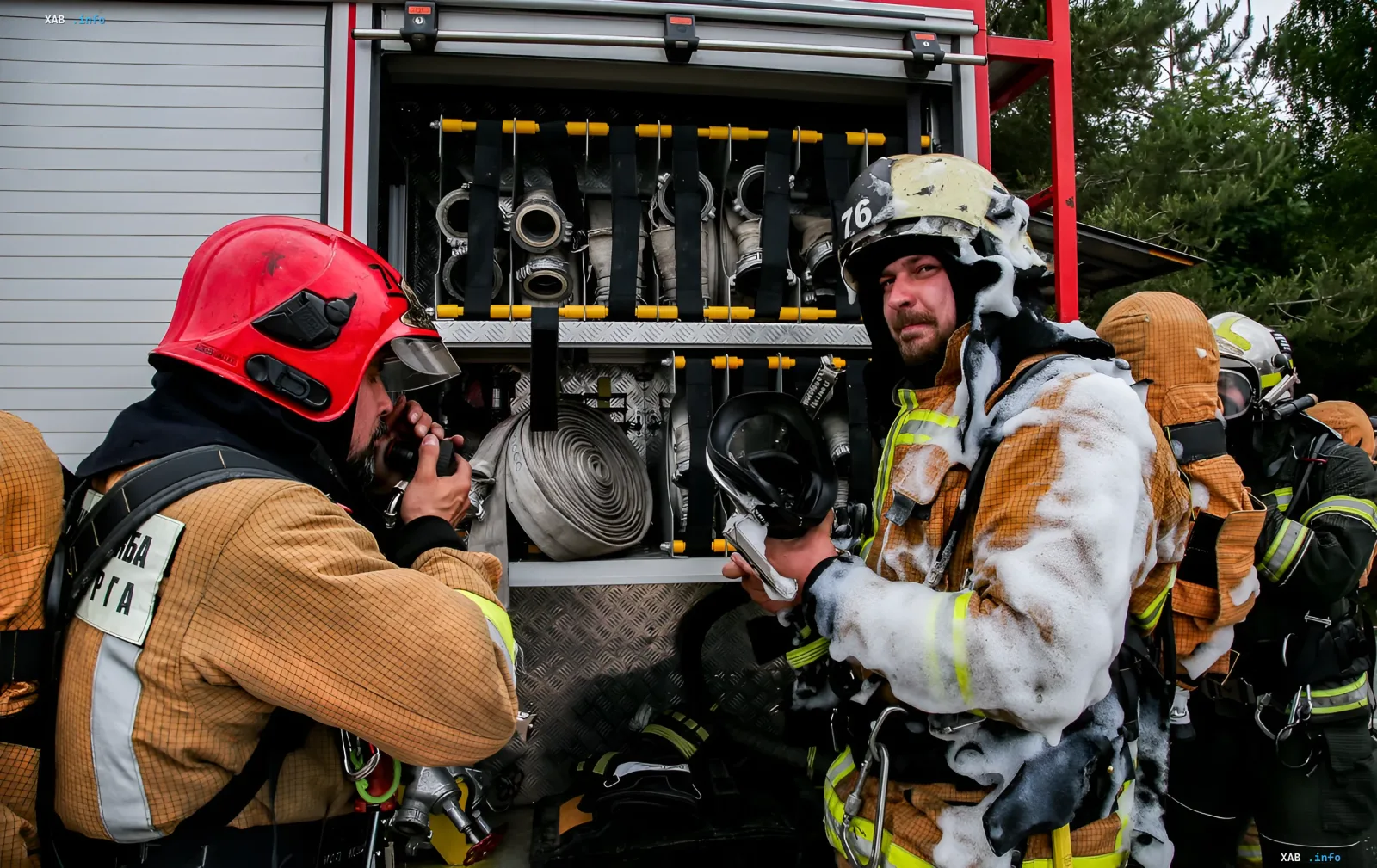 Firefighters in protective gear work at a damaged ammunition depot after explosions in the Belgorod region