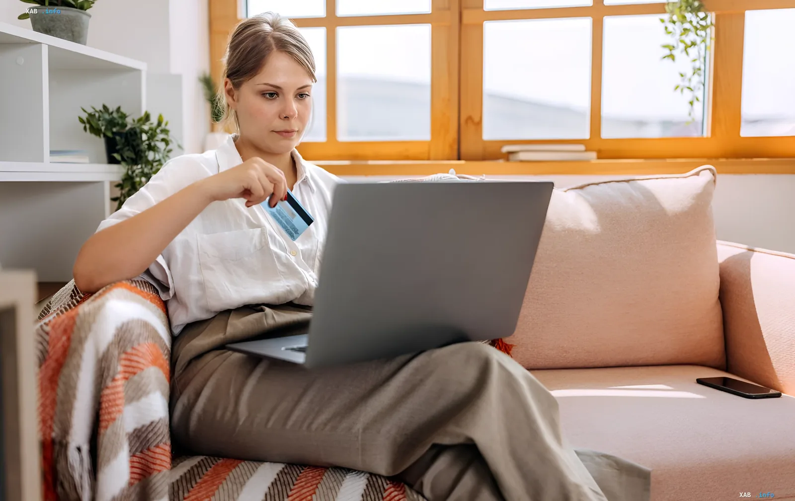 Woman with laptop and credit card on sofa — illustration of online sales and tax changes on OLX