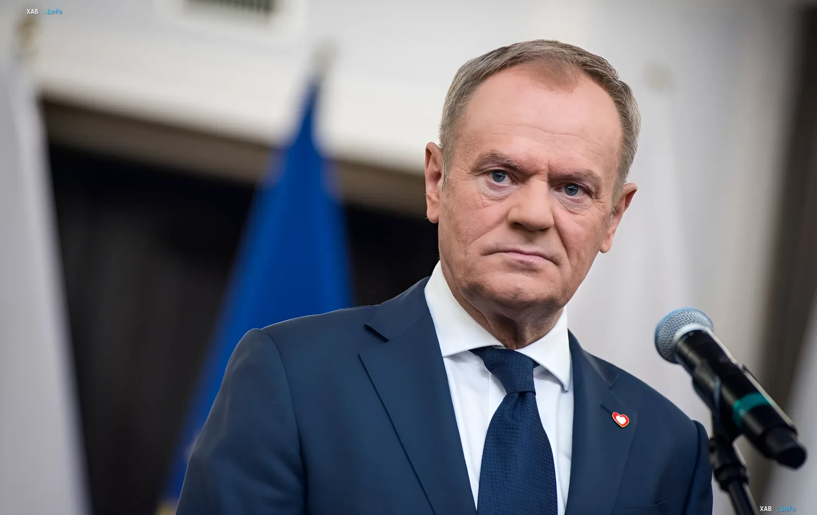 Donald Tusk in a blue suit delivers a speech, emphasizing the importance of Poland's role in peace negotiations