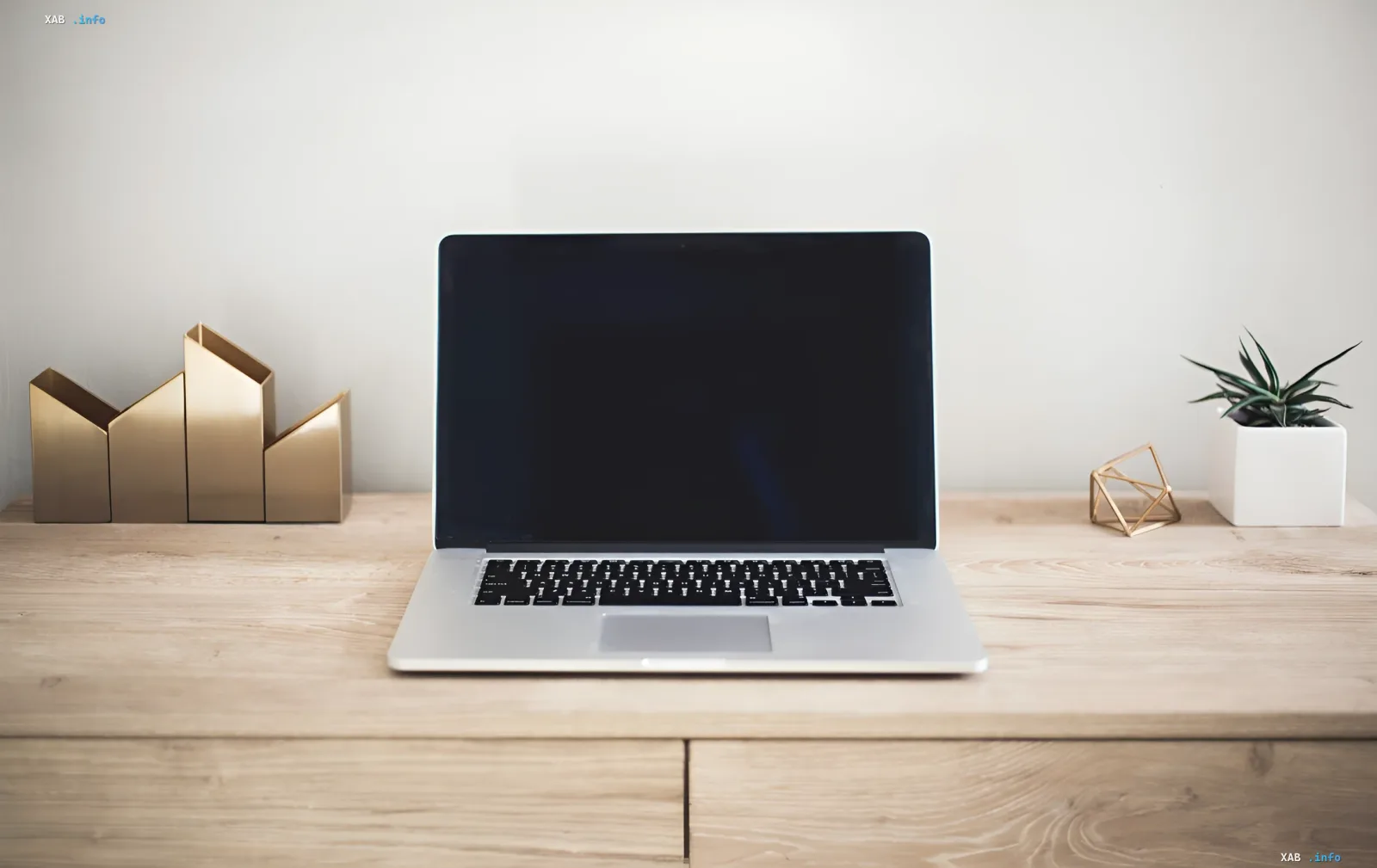 MacBook на деревянном столе с пустым экраном — символ перехода macOS 27 Golden Gate от Intel к Apple Silicon и ИИ-центричной эре с жесткими ограничениями