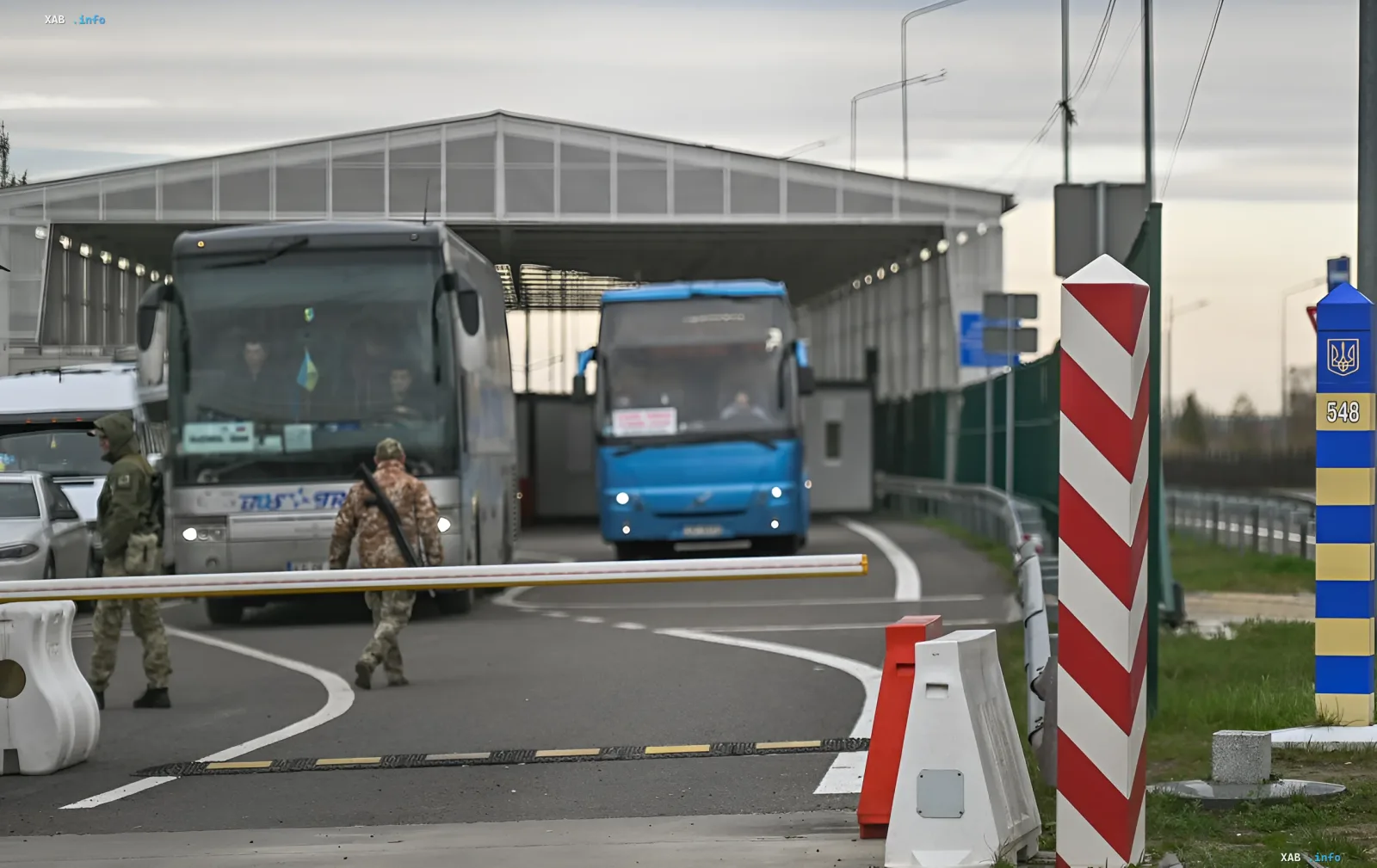 Queue of buses and cars at Ukrainian border with soldiers checking documents — typical scene of traffic jams when leaving the country