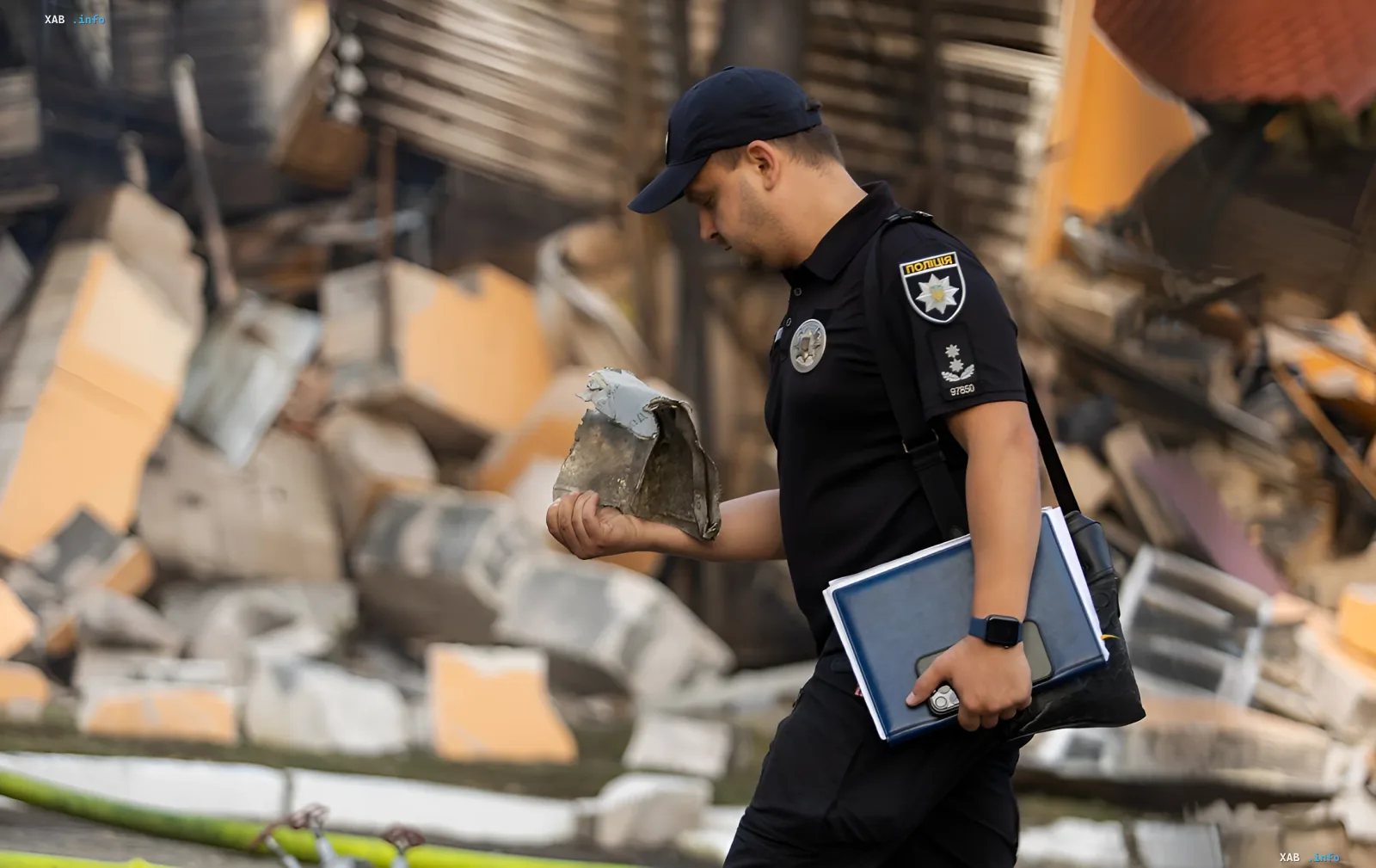 Ukrainian police officer inspecting debris after destruction, symbolizing the importance of salary increases for law enforcement officers