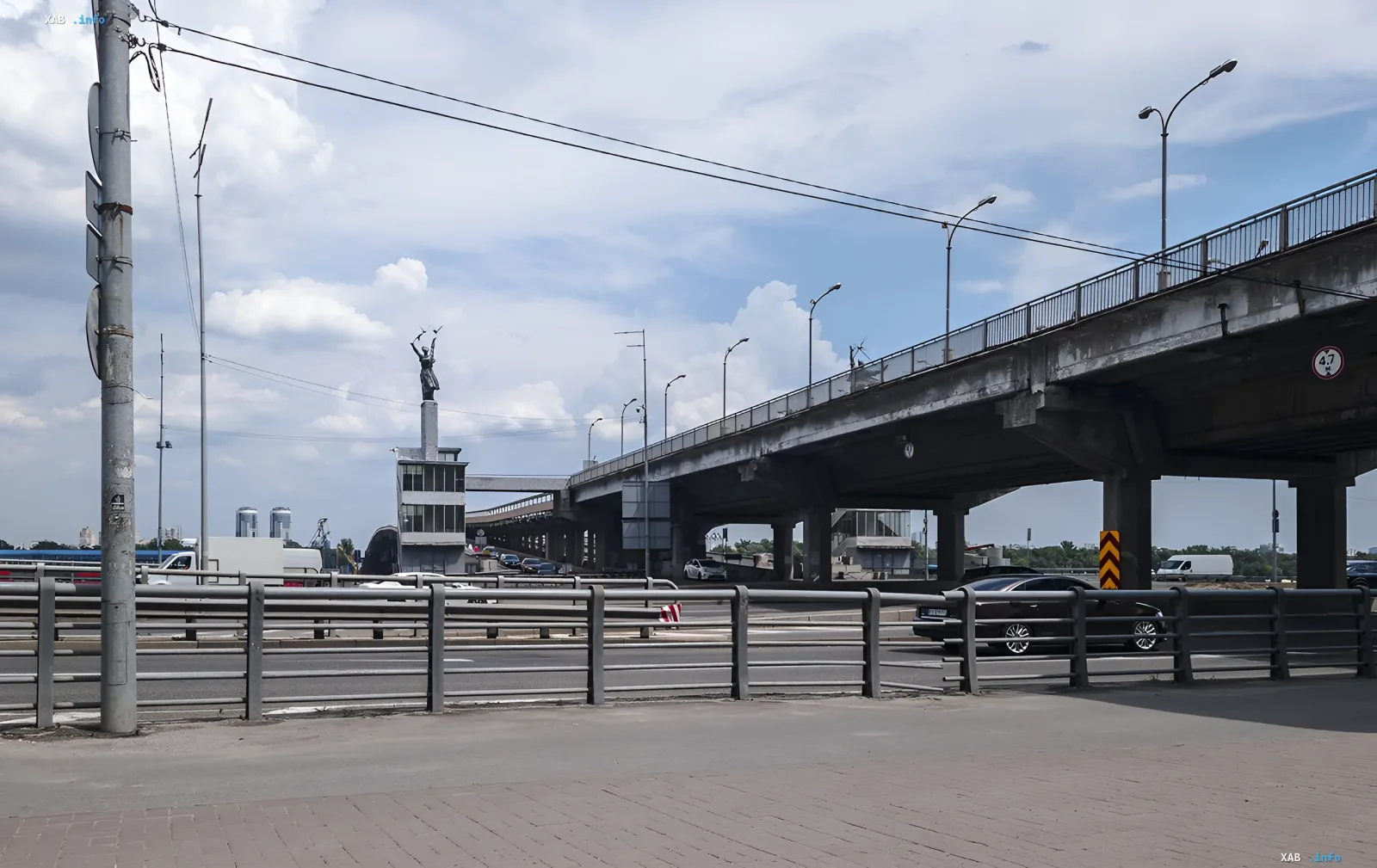 Міст Метро у Києві 11 червня: вигляд на ділянку дороги з частковим обмеженням руху через ремонтні роботи, видно статую та транспортний потік
