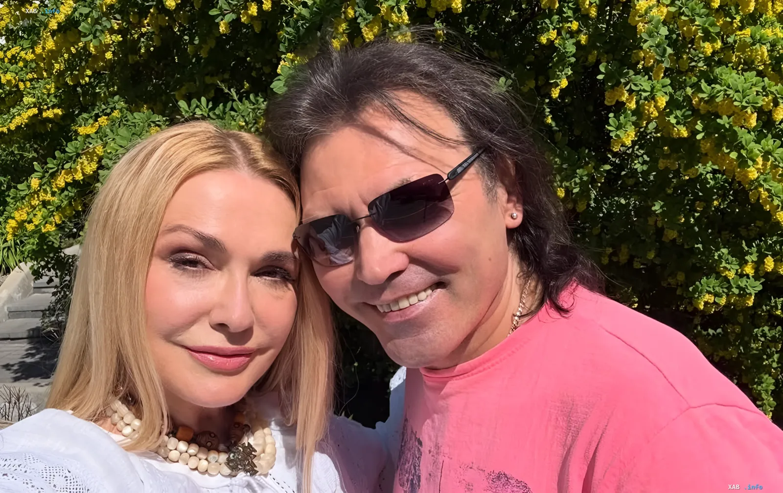 Olga Sumskaya and Vitaliy Borysiuk against flowering bushes — an example of harmonious relationships despite sleeping in separate rooms