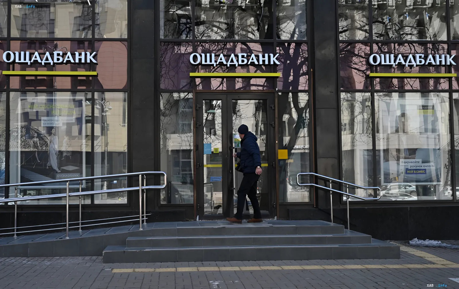 Філія Ощадбанку з вивіскою на фасаді, де клієнт заходить у будівлю — ілюстрація до новини про технічні роботи 14 червня