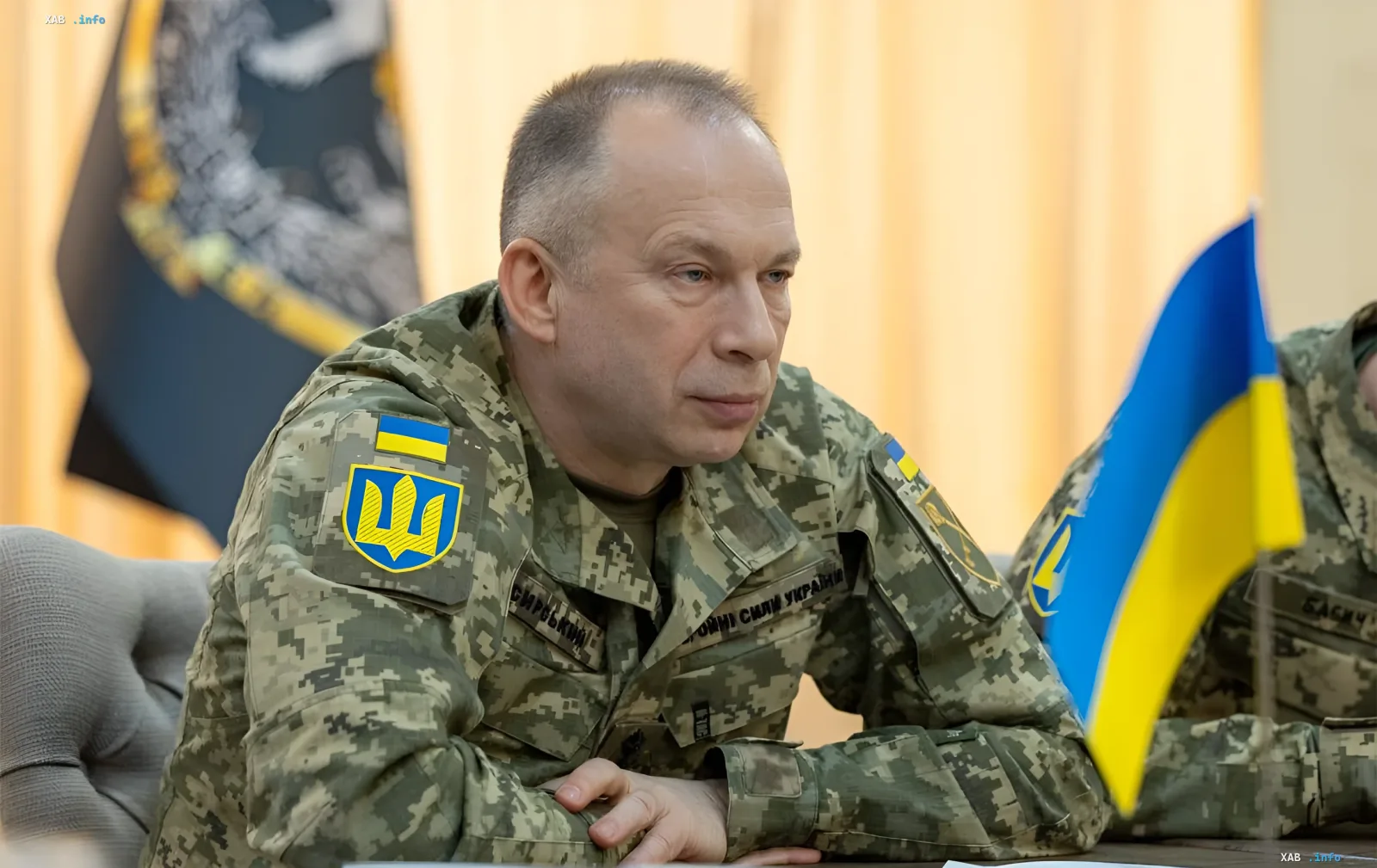 Генерал-лейтенант Сергей Сирский в камуфляжной форме с украинским гербом на плече, сидящий за столом с флагом Украины, обсуждает эффективность украинских дронов