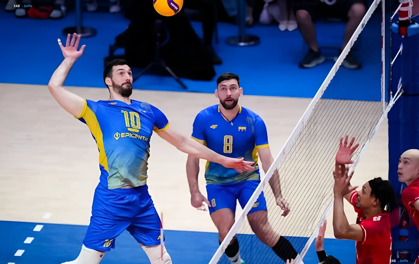 Украинские волейболисты в синих формах с номерами 10 и 8 атакуют мяч во время матча против Китая в Лиге наций