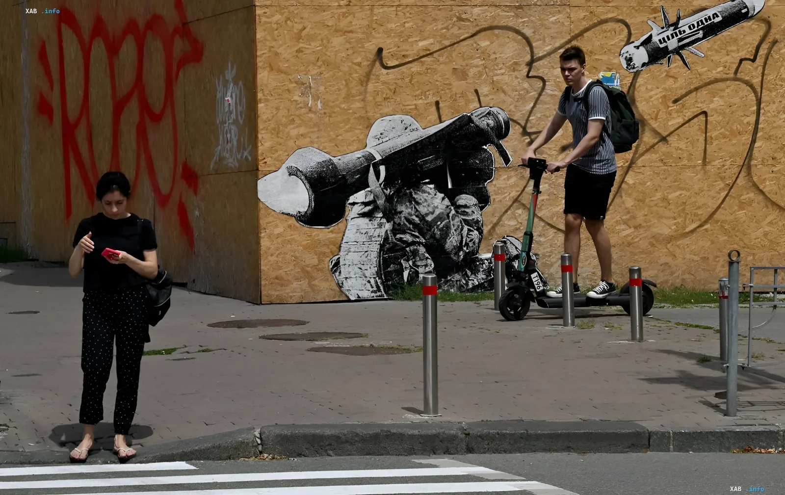Young man on an electric scooter in front of graffiti-covered walls in a Ukrainian city, illustrating the topic of e-scooter regulation