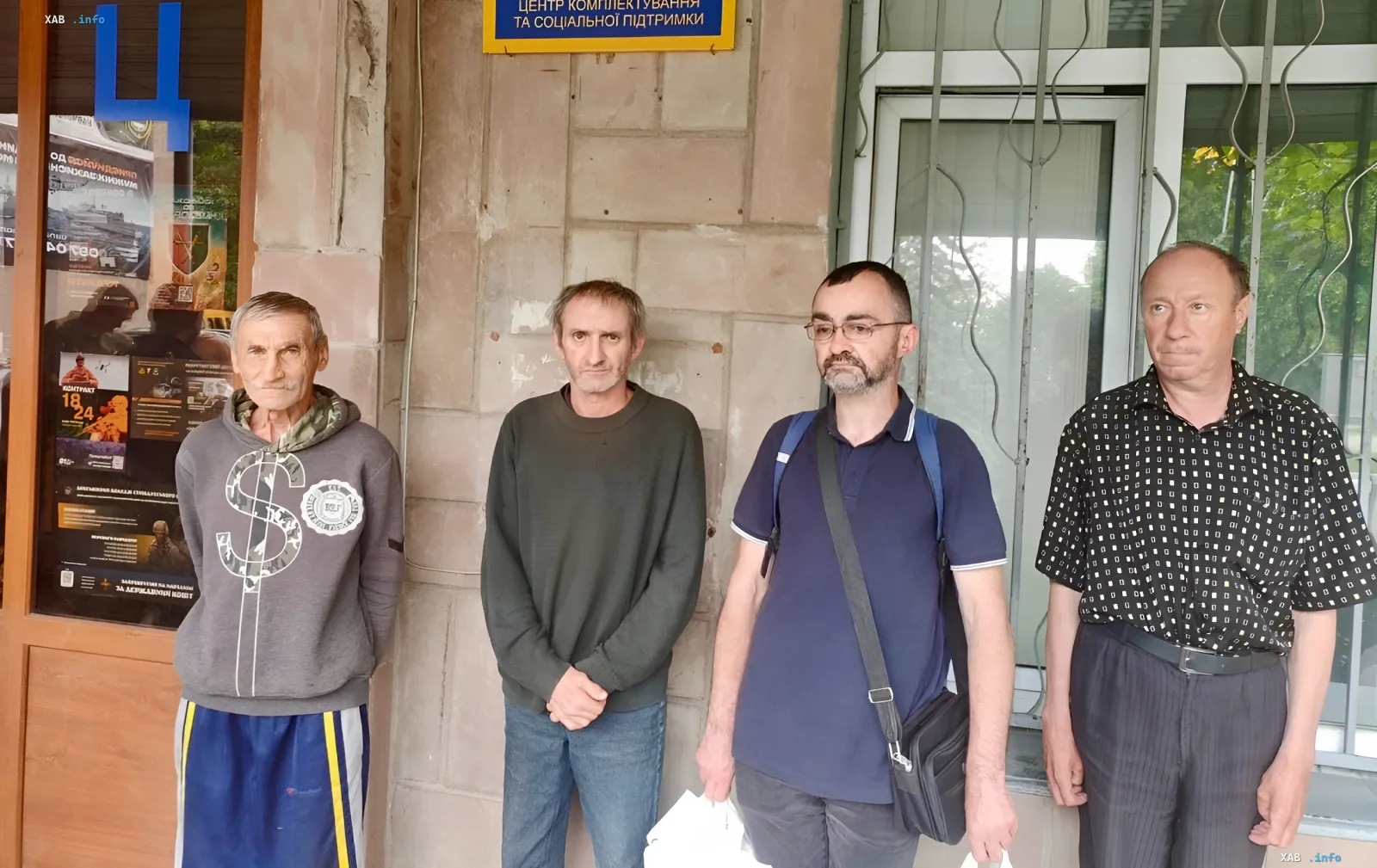Four men released by the Ombudsman from Ternopil TCK stand in front of a comprehensive service center building