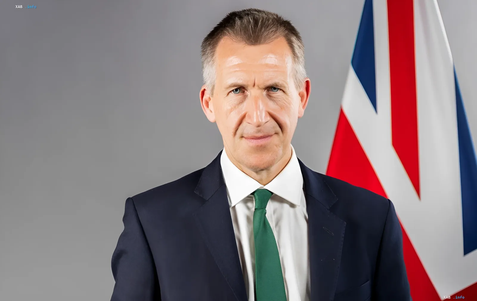 Dan Jarvis, neuer britischer Verteidigungsminister, im Anzug vor der britischen Flagge