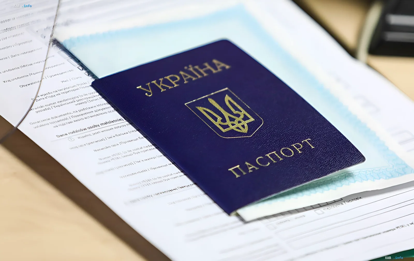 Український паспорт на фоні документів — символ подвійного громадянства та необхідності подання декларації про відмову від іноземного паспорта до 16 липня 2026 року