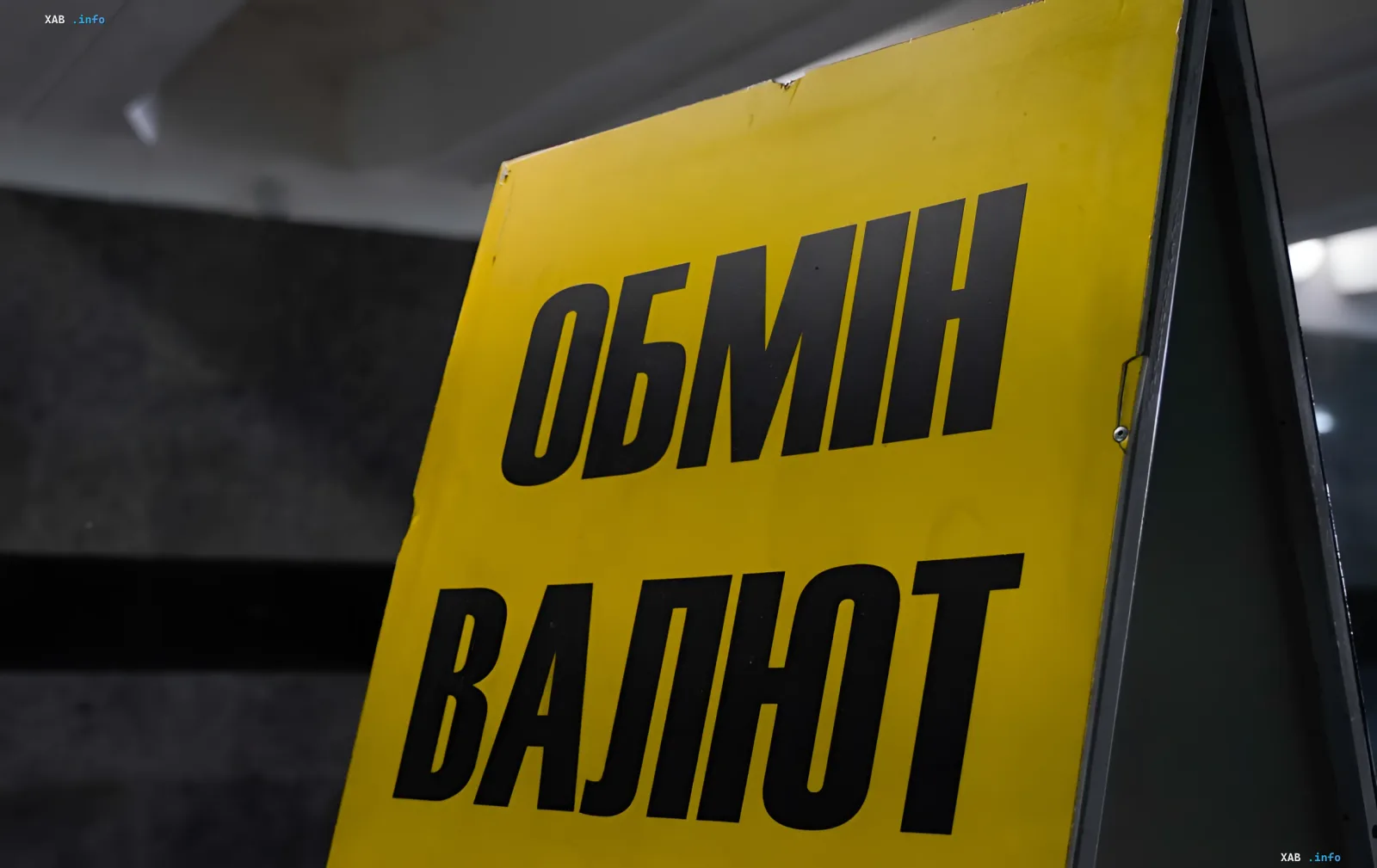 Желтый вывесочный знак с надписью 'ОБМІН ВАЛЮТ' — символ валютного обмена в контексте новости о снижении курса доллара и евро 12 июня