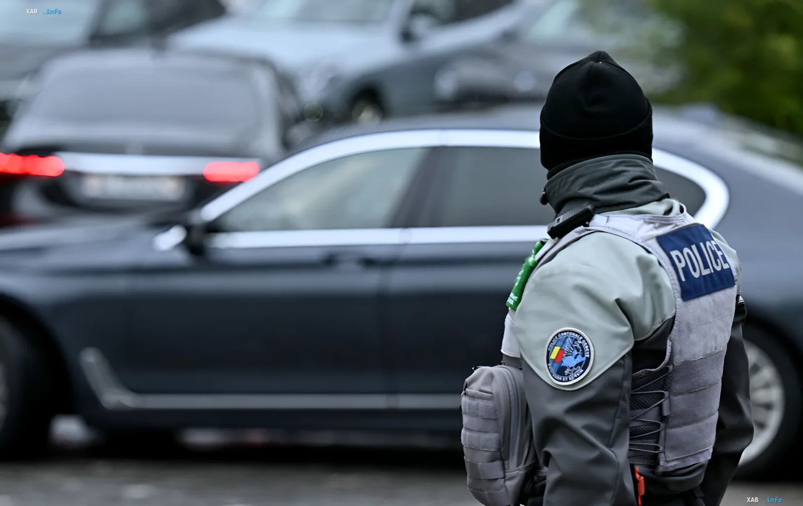 Швейцарский полицейский в защитной экипировке на фоне патрульных машин во время протестов перед саммитом G7 в Женеве