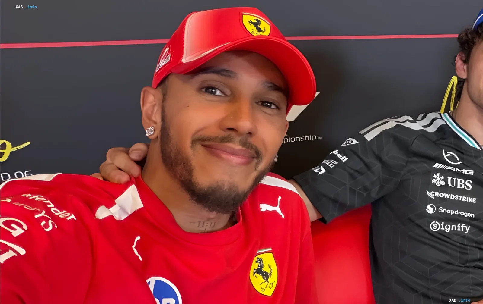 Lewis Hamilton in Ferrari gear with a smile on his face, symbolizing his first victory for the team