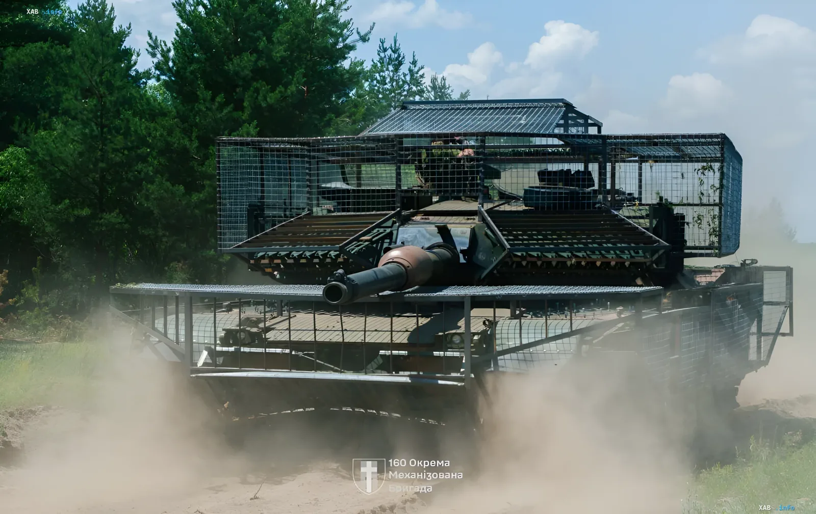 Украинский танк Abrams с уникальной сетчатой броней «Люцифер» в движении по полю, демонстрируя инновации 160-й бригады