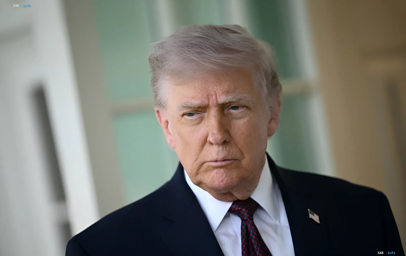 Дональд Трамп в деловом костюме с серьезным выражением лица, обсуждая последствия конфликта в Иране и мир в Украине