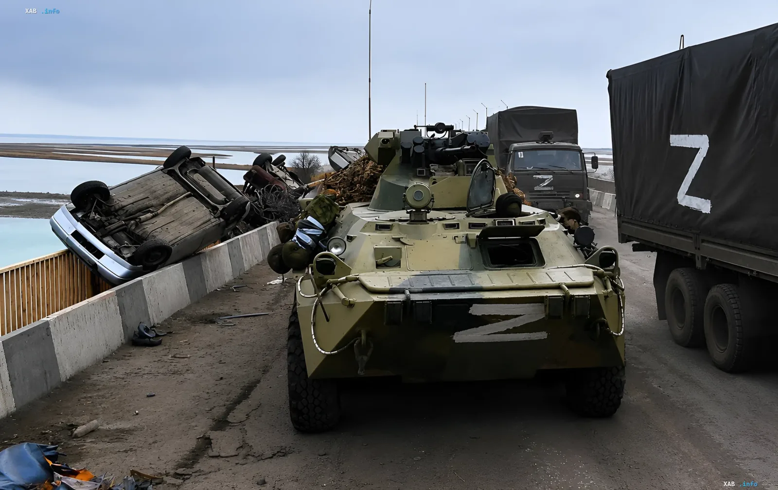 Военные грузовики с буквой Z и бронетранспортер на Крымском мосту рядом с перевернутым автомобилем после удара