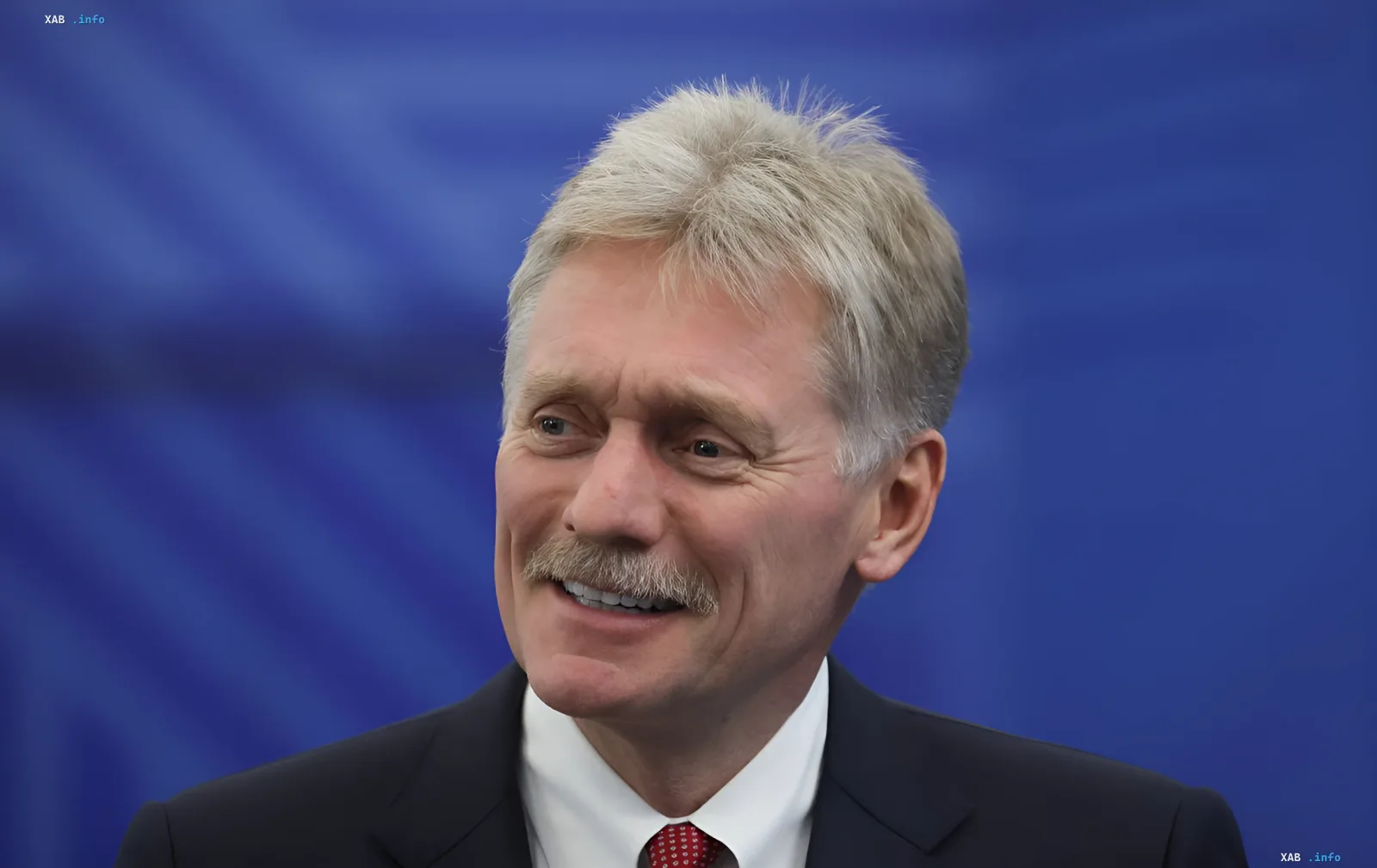 Dmitry Peskov against a blue background, commenting on Moscow's rejection of Zelensky's meeting proposal with Putin at the G7 summit