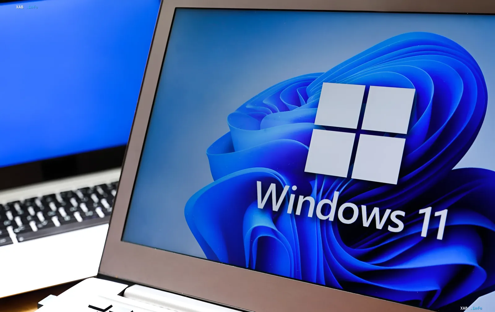 Laptop-Bildschirm mit Windows 11-Logo und blauem abstraktem Hintergrund, der das Interface-Update und die Einführung von Low Latency Profile symbolisiert