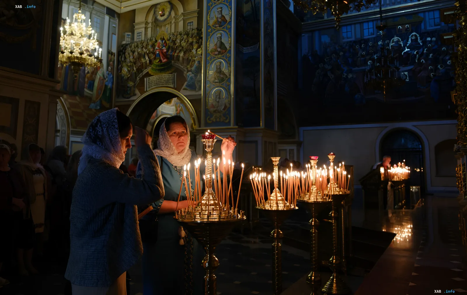 Женщины в платках зажигают свечи в православном храме, иллюстрируя тему веры без привязки к конкретной церкви