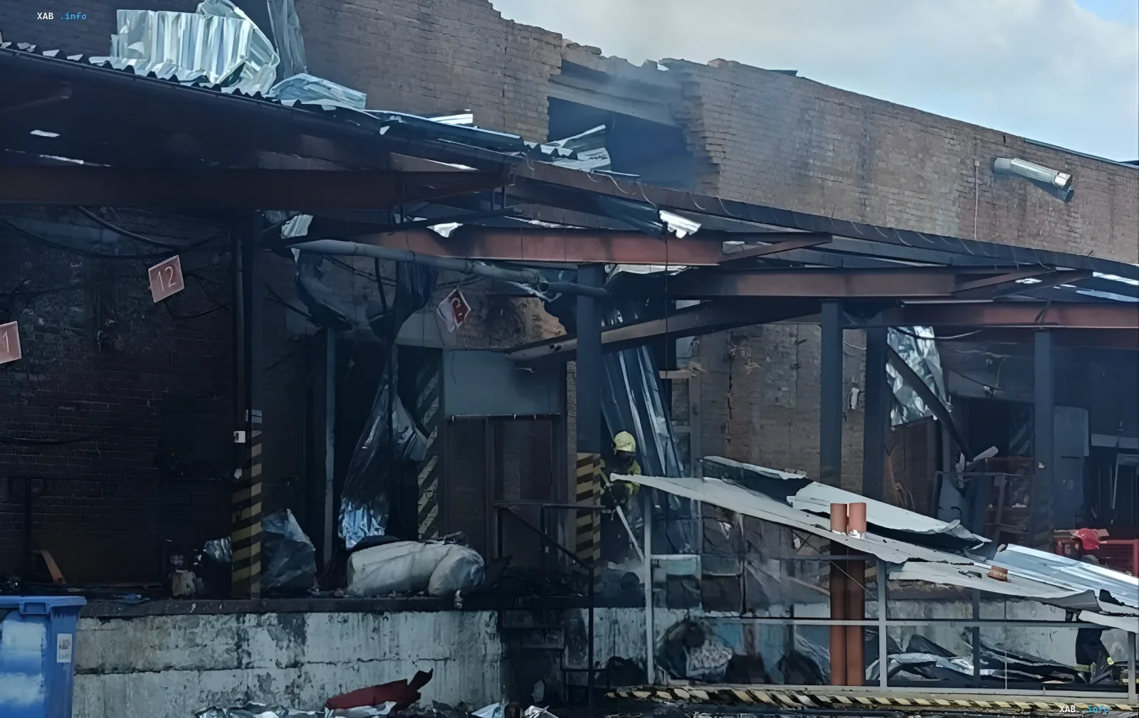 Aftermath of Russian drone attack on Nova Poshta sorting terminal in Sumy: destroyed roof, burnt structures, and firefighters at the scene