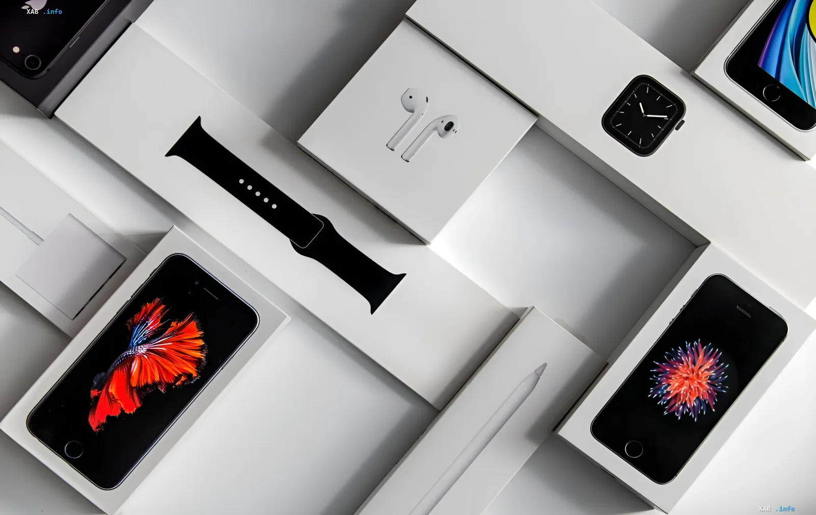 Набор гаджетов Apple: iPhone, Apple Watch, AirPods и Apple Pencil в белых коробках, символизирующий рост цен на продукцию компании