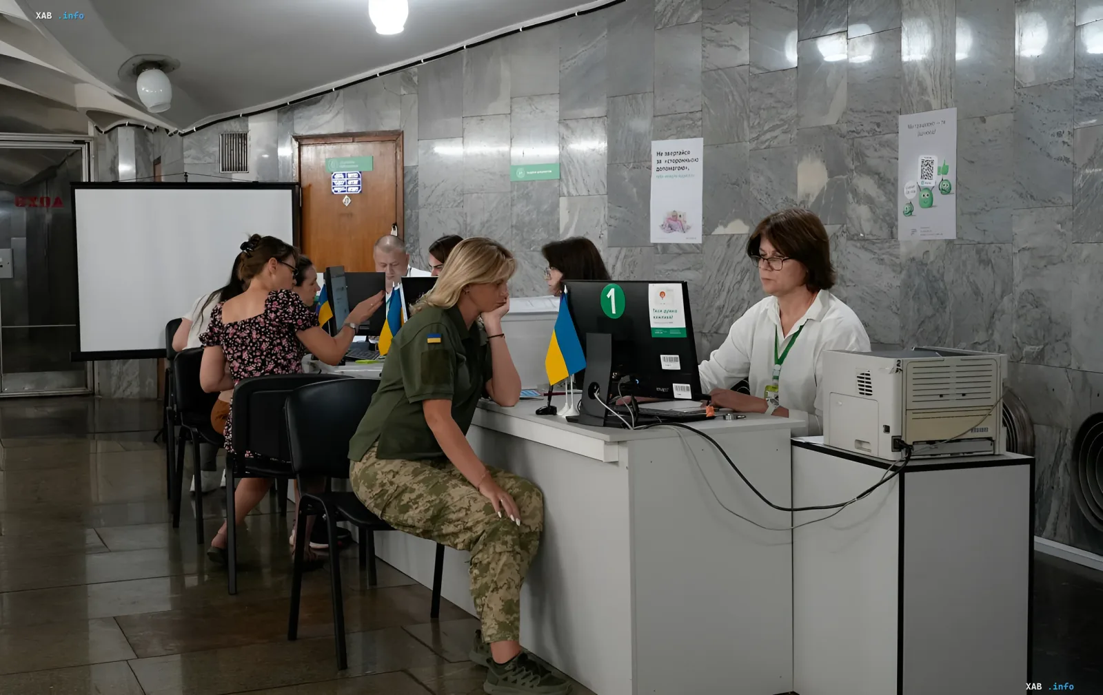 Befreiter Soldat in Uniform interagiert mit einem Mitarbeiter einer staatlichen Behörde an einem Schalter mit ukrainischer Flagge. Die Szene illustriert die Beantragung von kostenlosen Führerscheinen und Fahrzeugschein.