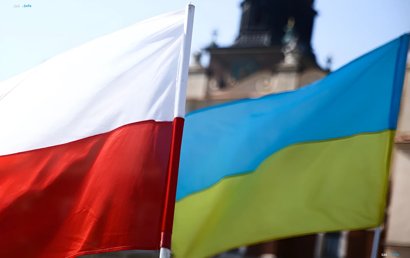 Флаги Польши и Украины на фоне исторического здания, символизирующие диалог между странами и реакцию общества на отмену ордена Зеленскому