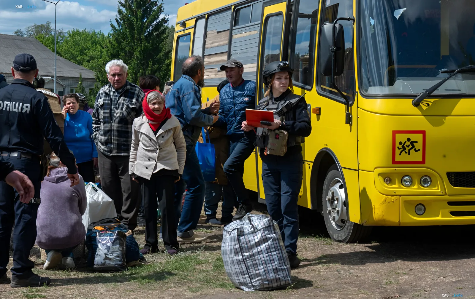 Эвакуация жителей Черниговской области: люди с вещами у желтого автобуса под присмотром полиции
