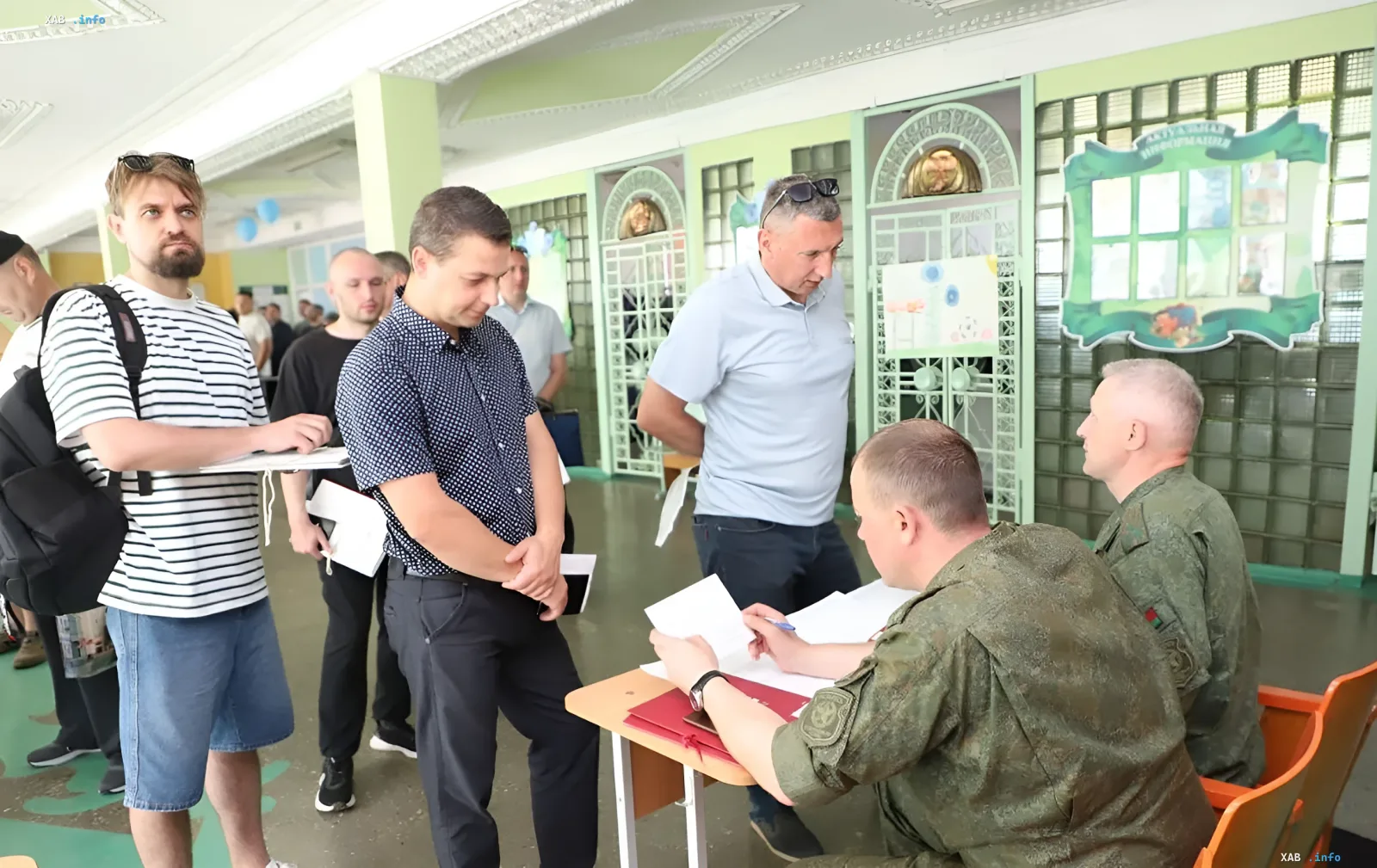 Мужчины стоят в очереди в военкомате Гродненской области, ожидая проверки документов во время мобилизационных учений