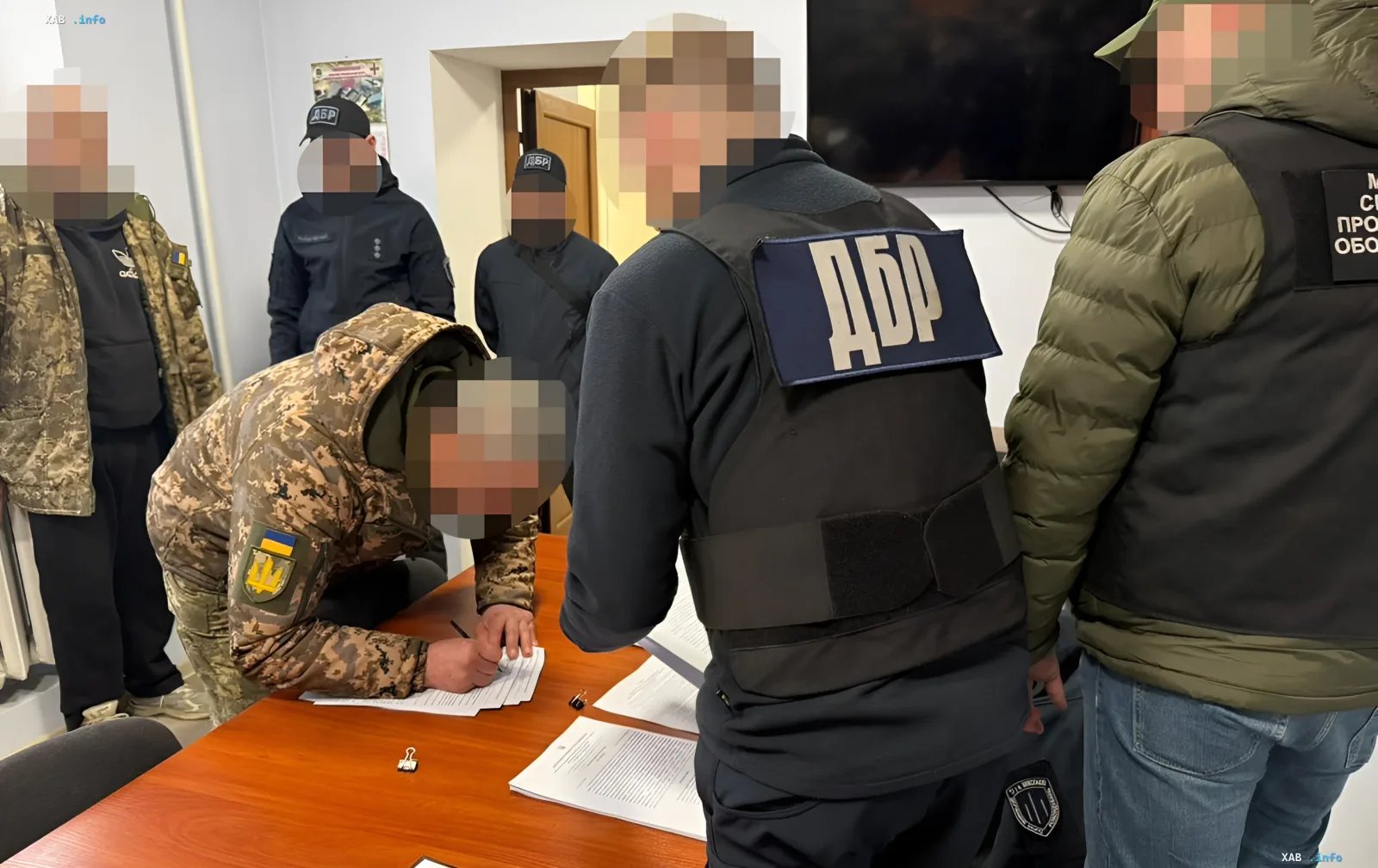 Сотрудники ДБР допрашивают мужчину в военной форме в офисе, связанный с делом о жестоком обращении ТЦК в Николаевской области