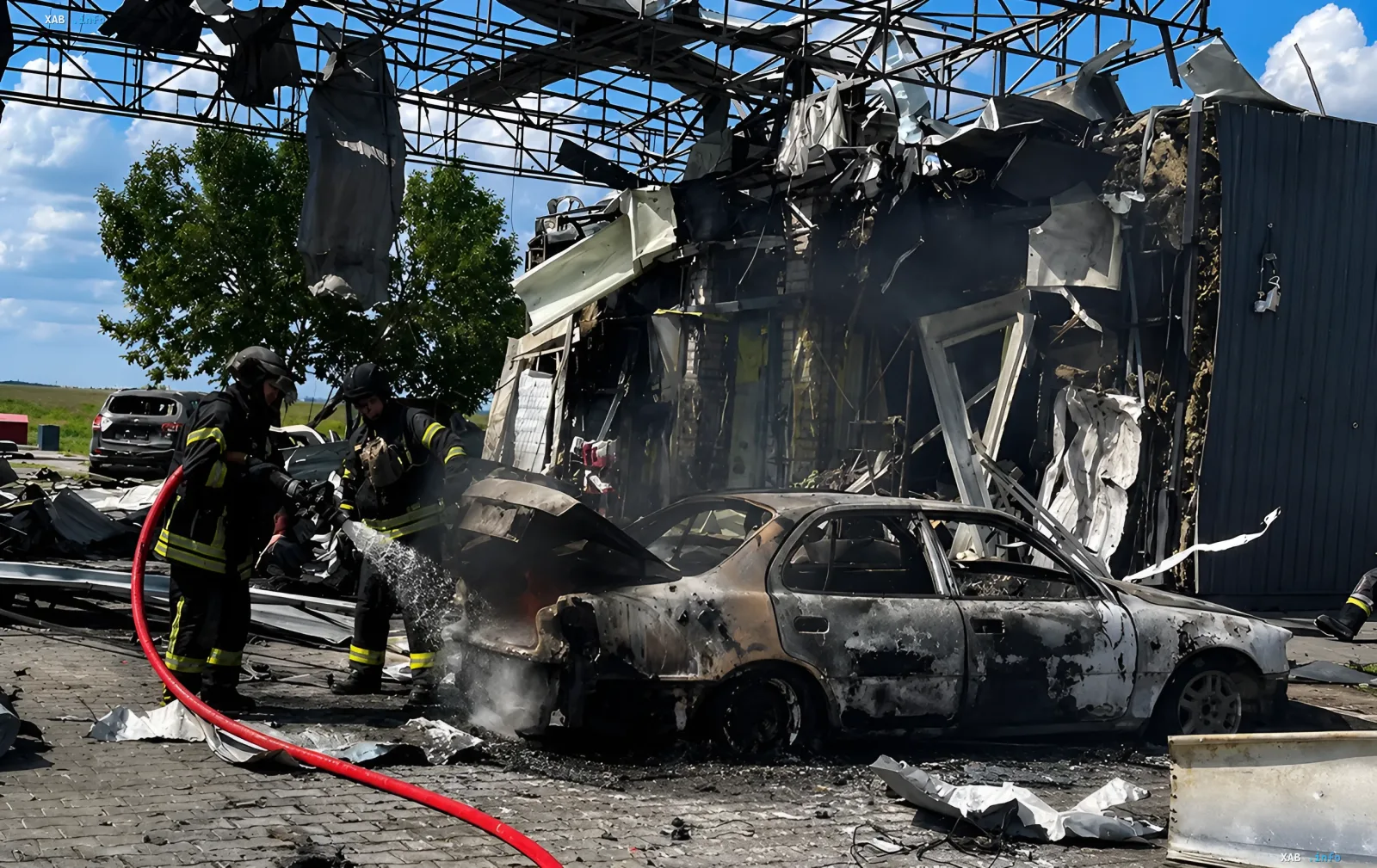 Firefighters extinguish a burning car at the explosion site in Kherson region where a Norwegian People's Aid sapper died