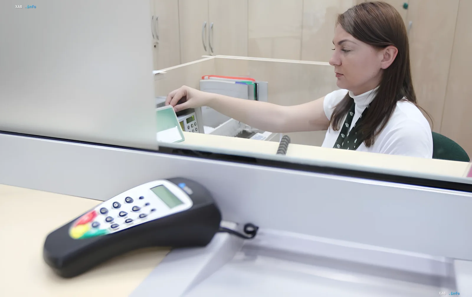 Cashier at an exchange office processing currency, illustrating the rate difference when exchanging old and new dollars