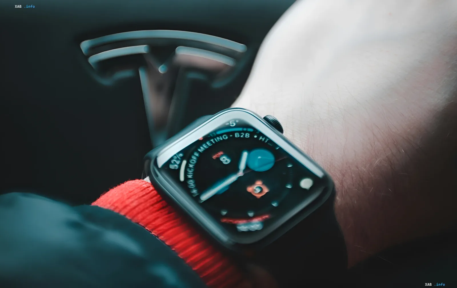 Apple Watch Smartwatch am Handgelenk mit Tesla-Logo im Hintergrund, das den Datenleck von Apple und Tesla durch die Tata Electronics-Fabrik symbolisiert