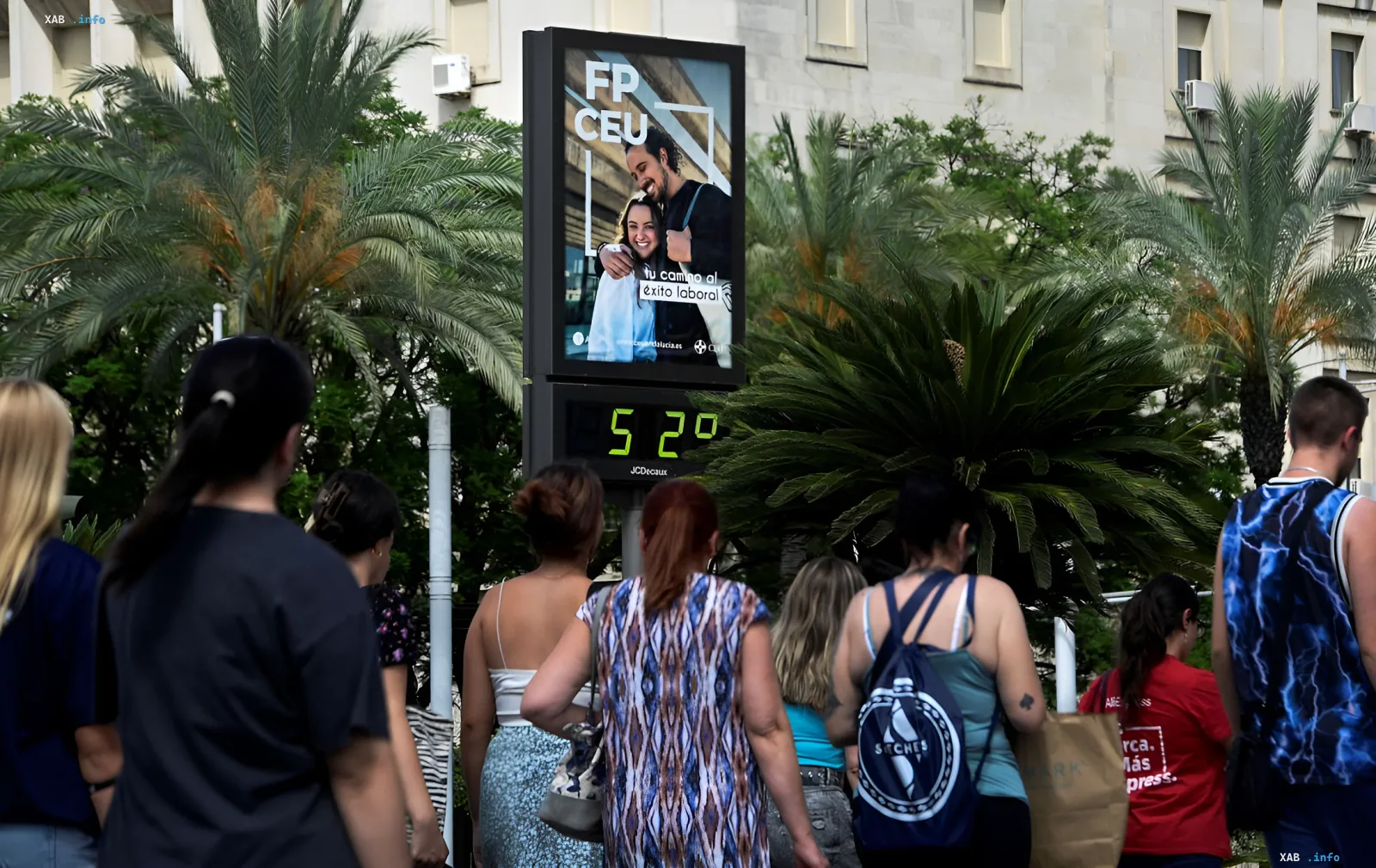 Цифровой термометр показывает 32°C на фоне пешеходов в Европе, иллюстрируя аномальную жару и её влияние на повседневную жизнь