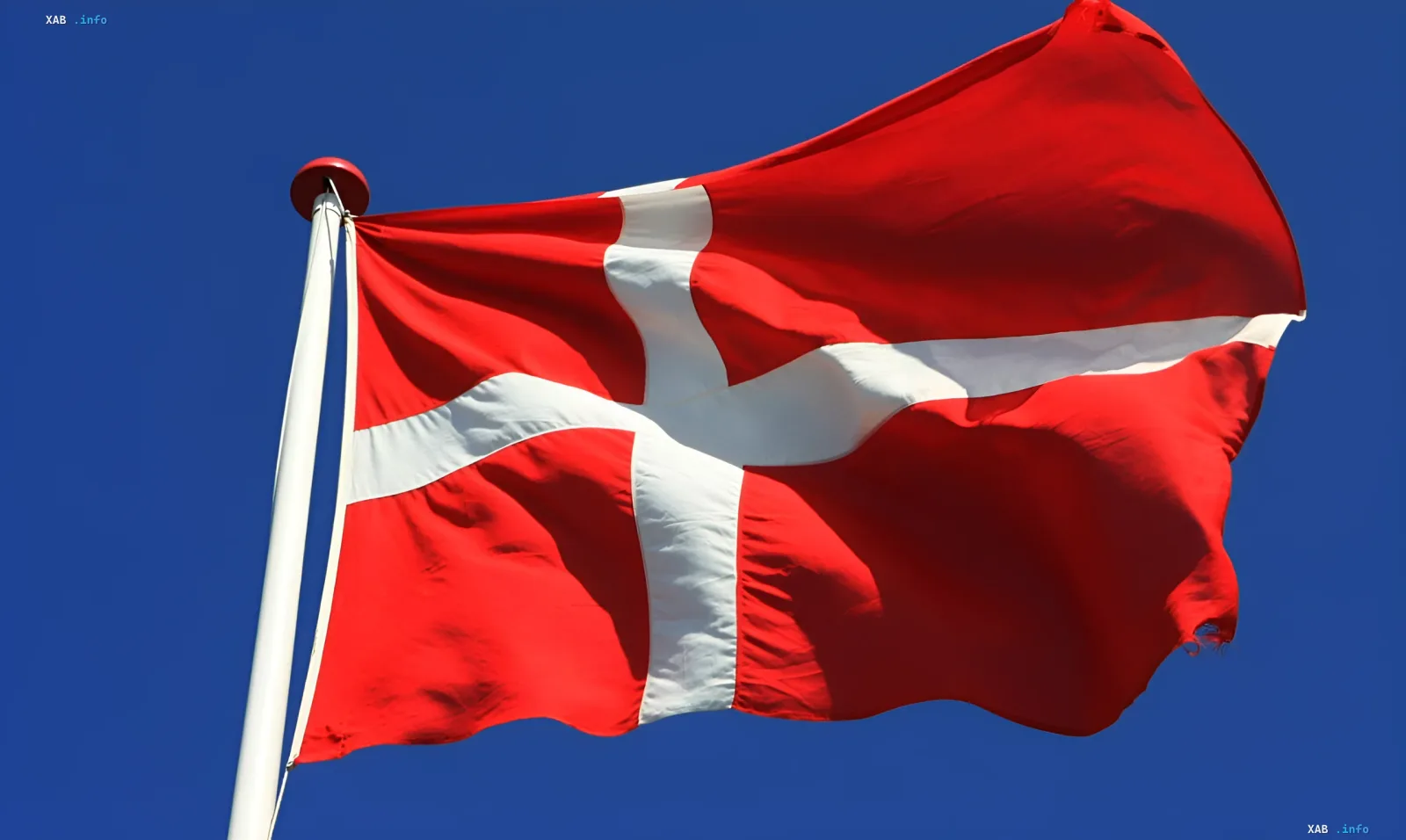 Dänische Flagge vor blauem Himmel, die neue Asylregeln für Männer aus der Ukraine symbolisiert