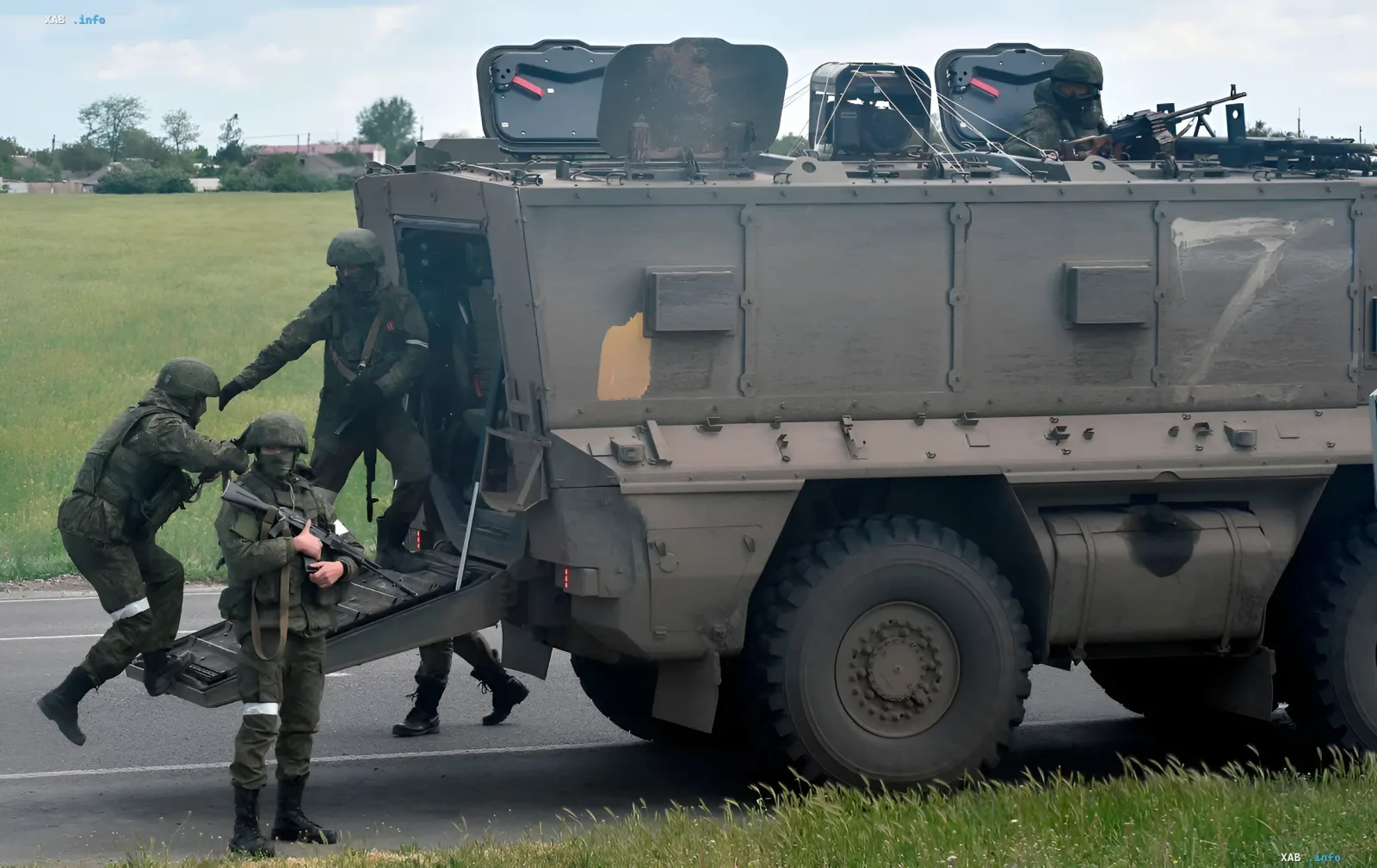 Українські військовослужбовці у камуфляжі спускаються з бронетранспортера БТР-80 на фоні полів, що символізує бої за Кінбурнську косу та стратегічний плацдарм