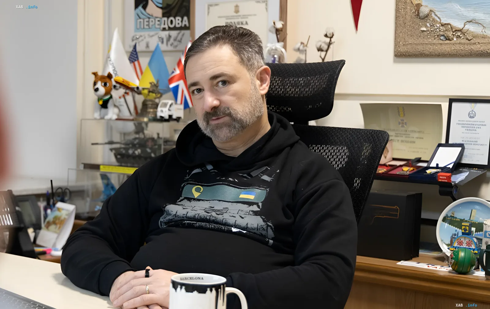 Глава «Укрпочты» в офисе, на фоне флагов Украины, США и Великобритании, обсуждает системные нарушения и убытки компании