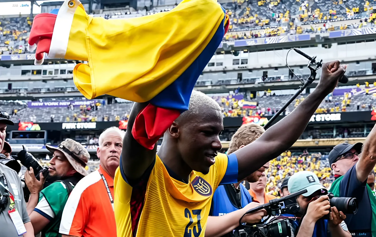 Ecuador national team player in yellow jersey number 23 celebrates victory waving the national flag at the stadium