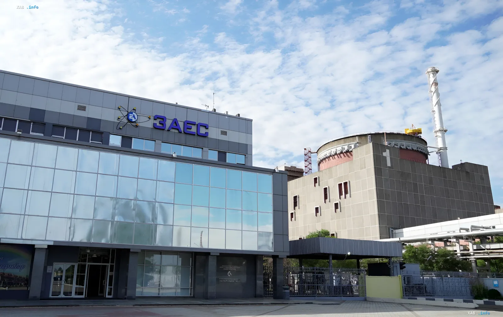 Zaporizhzhia NPP building with logo and reactor unit in background — symbol of completed repairs, yet blackout threat remains per IAEA findings